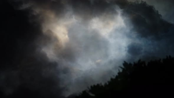 4k dark clouds in the sky with thunderstorm trees foreground