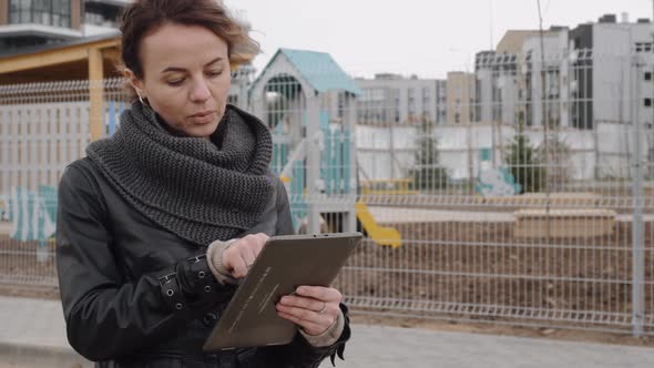 The Designer Girl Communicates with Her Client Using a Tablet.