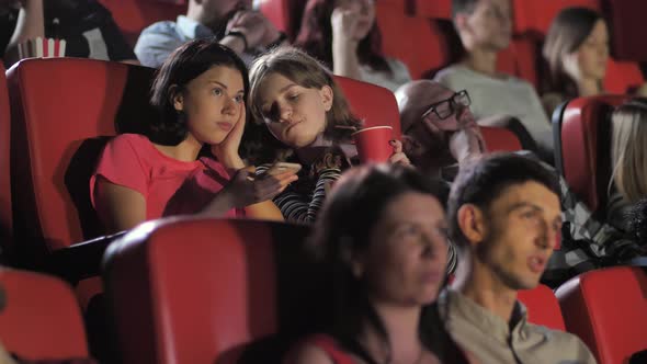 Teen Girls Using Smartphone During Movie in Cinema