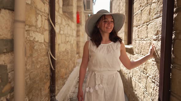 Dolly Shot Portrait of Smiling Satisfied Woman Walking in Slow Motion on Sunny Narrow Street in