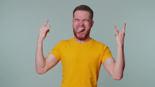 Overjoyed Happy Man Showing Rock n Roll Gesture By Hands Cool Sign Shouting Yeah with Crazy Face