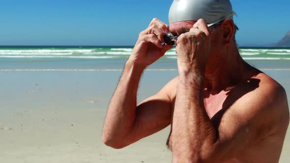 Senior man wearing swim goggle at the beach