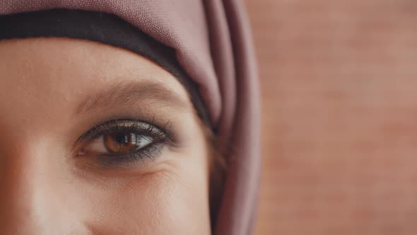 The Eye of a Muslim Woman Looks at the Camera. A Painted Girl in a Hijab Looks at the Camera with