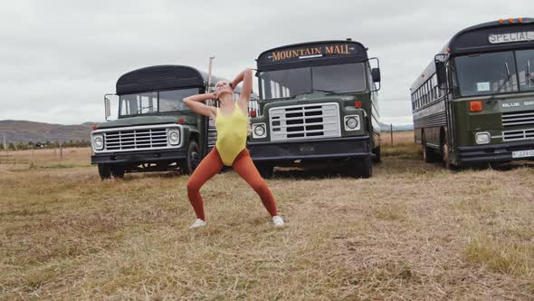 Dancer In Yellow And Orange Performing Routine By Busses