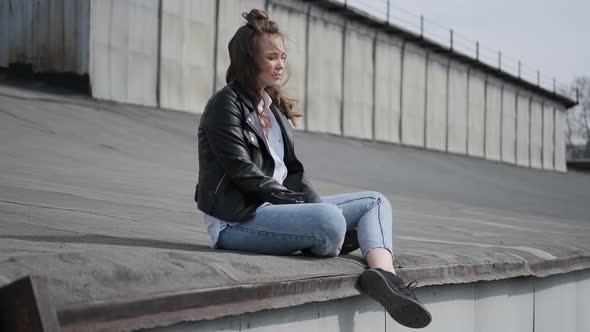 Hipster Girl Sits on the Roof and Enjoys a Warm Spring Day.