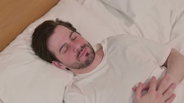 Casual Young Man Waking Up From Sleep in Bed