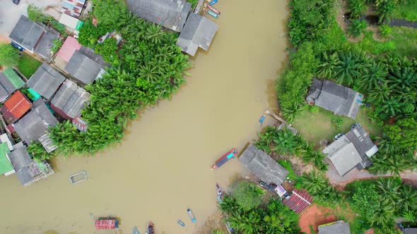 An aerial view over a fishing village by a canal in the countryside