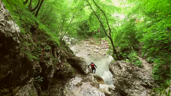 Aerial view of couple jumping in sliding rock at Soca river, Slovenia.