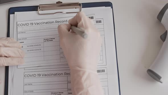 Hand Filling in Vaccination Record Card