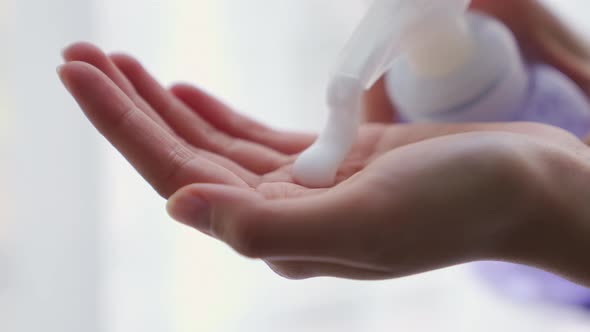 Hands press the alcohol bottle to clean.