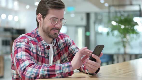 Attractive Male Designer Using Smartphone