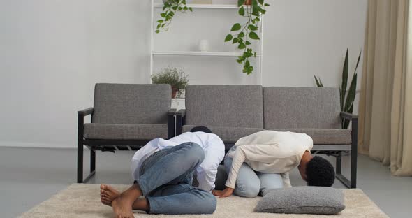 Couple Young Parents Looking for Child Under Sofa Playing Hide and Seek with Their Daughter Little