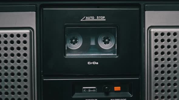 Vintage Transparent Audio Cassette Playing in Deck of an Old Tape Recorder