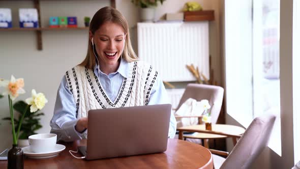 Handsome blonde woman talking by video call on laptop