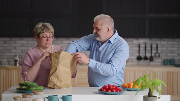 Retirees are Unpacking Bag with Fresh Food in Kitchen Home Delivery of Groceries Old Spouses are