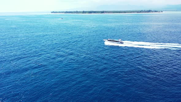 Tropical birds eye travel shot of a sandy white paradise beach and blue ocean background in colorful