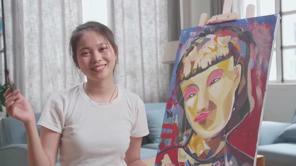 Asian Artist Girl Sitting And Holding Paintbrush Wipe The Sweat And Smiling After Finish Painting