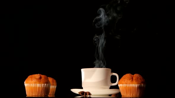 Steaming White Coffee Cup with Cakes, Anise, Cinnamon on Black Background