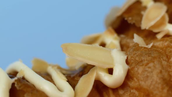 Macro shot of a croissant dessert on a blue background. Close-up, the camera slowly moves