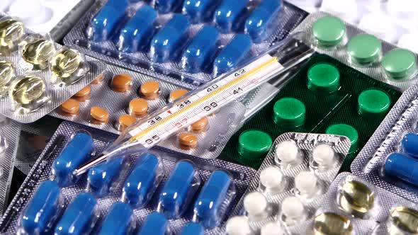 Thermometer on Different Pills, Rotation, Reflection, Macro, on Black, Top View