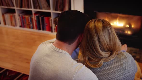 Couple relaxing near fireplace in living room