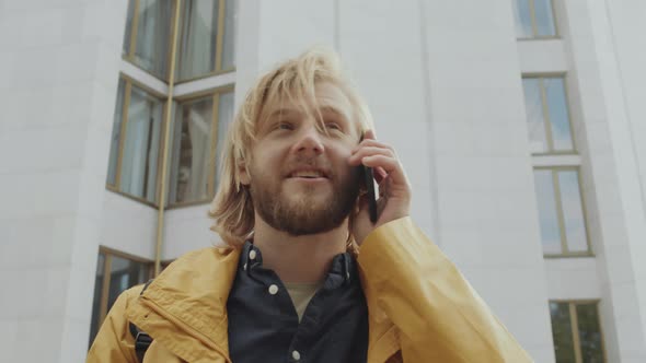 Young Man Talking on Mobile Phone on Street