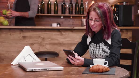 Confident Woman in Her 40s Texts on Smartphone