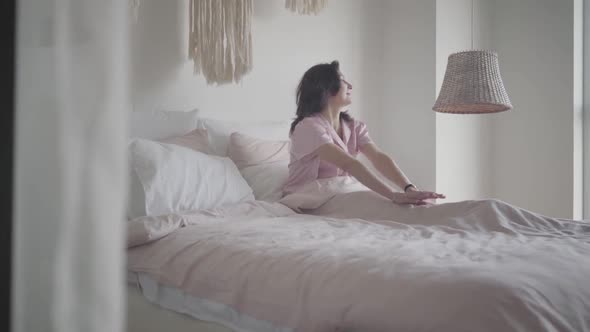 Wide Shot of Happy Adult Caucasian Woman Waking Up in the Morning. Portrait of Joyful Brunette Lady