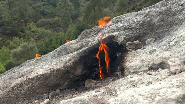 Flame of Methane Underground Emerges From Crack Between Rocks and Burns to Earth