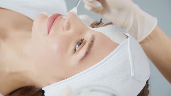 Beautician Applies Cleansing Mask Face with a Brush