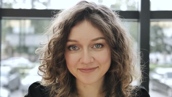 Lady with Light Makeup Smiles and Poses Looking Into Camera