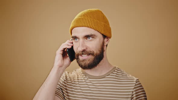Brutal Hipster in Hat Talks on Phone Aggressively Closeup