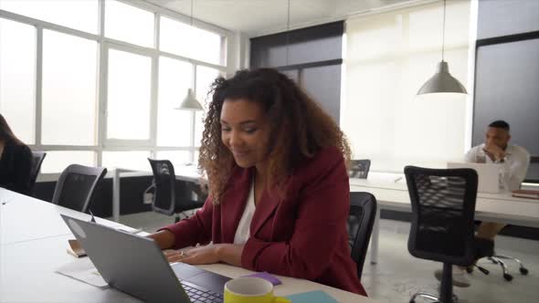 Businesswoman working in coworking space, having video call on latop