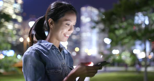 Woman Using cellphone with the background of Hong Kong city 