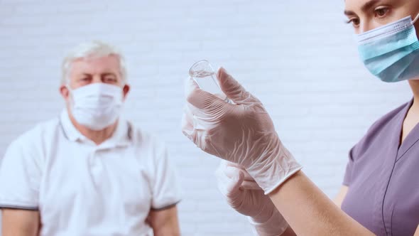 Young Woman Nurse Dials Medication Into Syringe for Patient