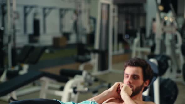 Middle Shot Portrait of Strong Bearded Young Man Doing Abs Exercises.