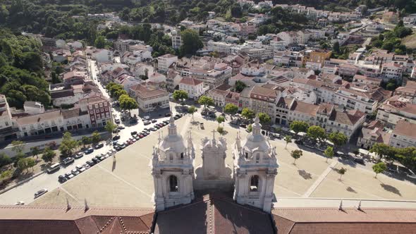 Aerial flying above the spires of Alcobaça monastery overlooking at the cityscape Portugal.