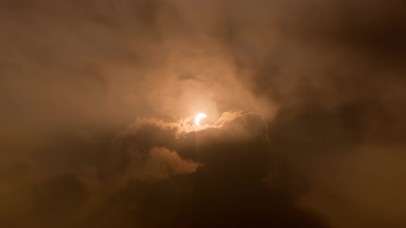 Partial solar eclipse with ray formation through the cloud.