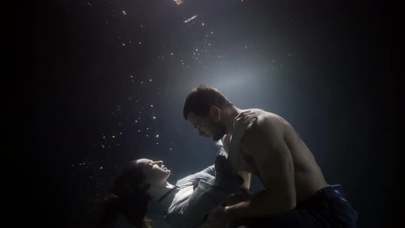 A Man Passionately Touches and Hugs His Girlfriend Underwater Lovers Deep Inside on a Dark