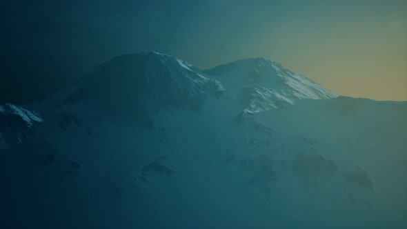 Dramatic Dark Rocky Mountain with Patches of Snow in Storm