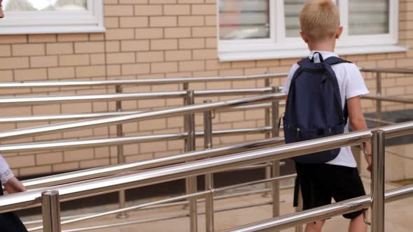 Small Children with Backpacks Go to School Together They Climb the Stairs