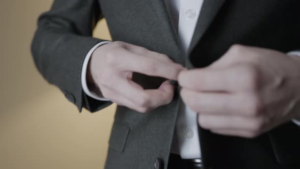 Close-up of gentleman adjusting suit jacket