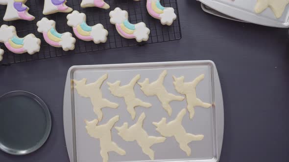 Step by step. Flat lay. Decorating unicorn sugar cookies with royal icing on baking sheet