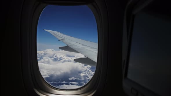 Wing of the Plane and Clouds View Through the Porthole