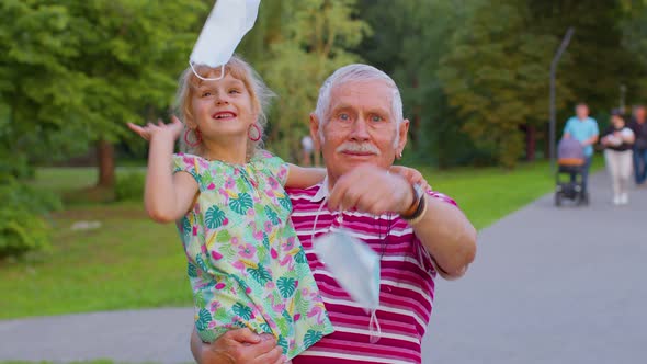Quarantine Coronavirus is Over Senior Grandfather with Grandchild Taking Off Medical Masks Celebrate