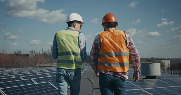 Engineer and Technician Discussing Between Solar Panels