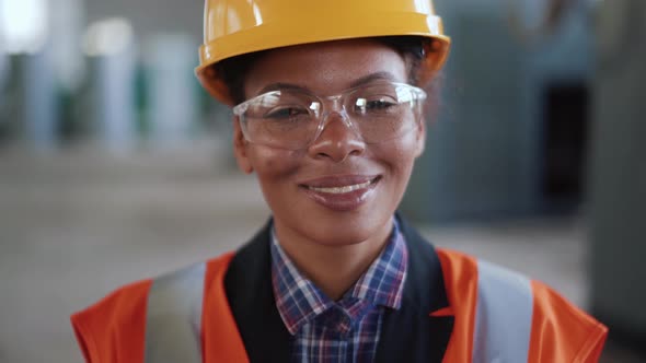 Smiling African woman engineer in uniform looking at the camera