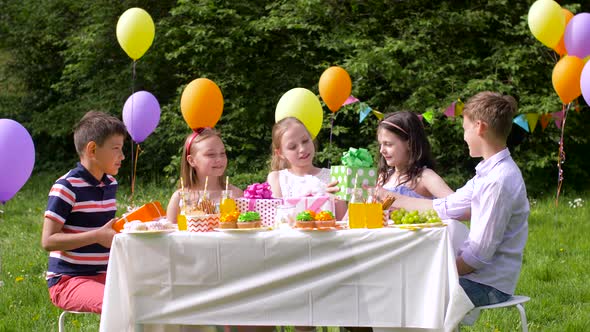 Kids Giving Presents To Birthday Girl at Party 