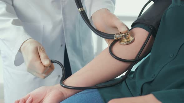 A Physical Therapist at a Clinic Measures a Man's High Low Blood Pressure