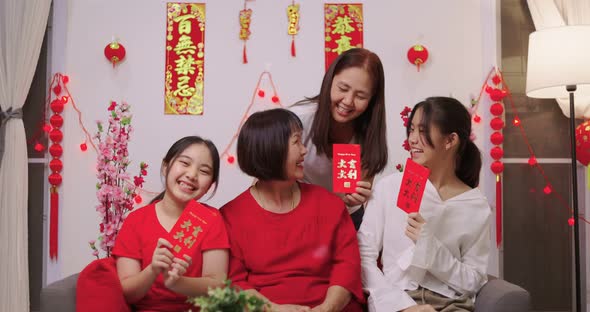 Happy Asian Multi Generations Family Celebrating Chinese New Year. Showing Lucky Red Envelope.